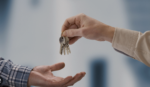 Hands exchanging a set of keys, symbolizing trust and responsibility in keyholding services for residential and commercial properties by Crown Security Services.