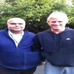 Two men standing together outdoors, one wearing a blue jacket and the other in a black hoodie, representing the personal connections and high-profile clientele of Crown Security Services in Birmingham.